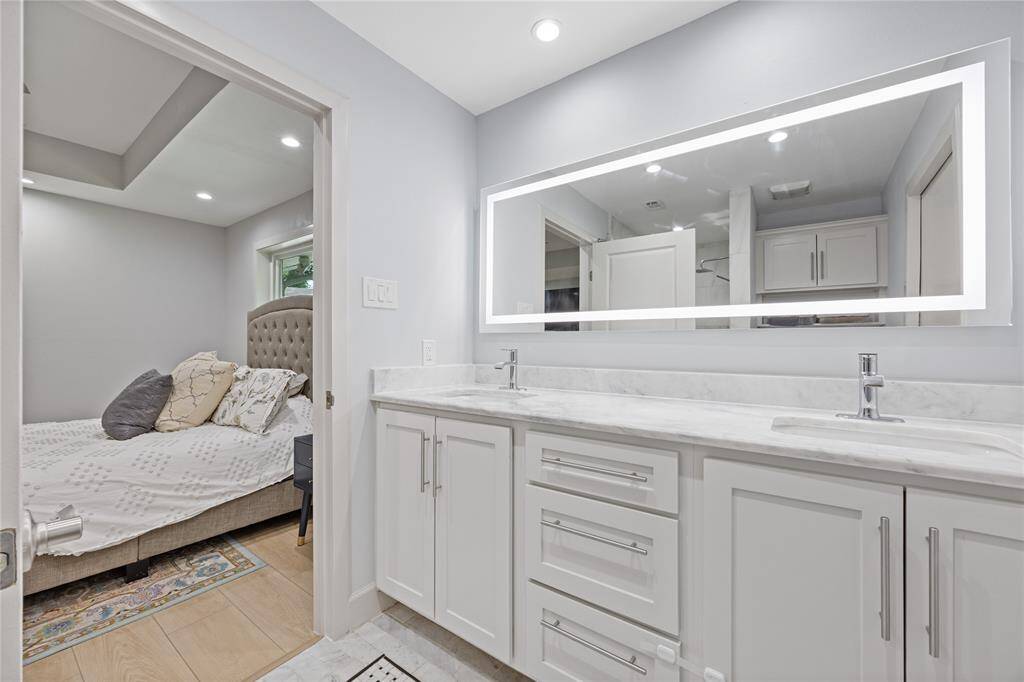 Primary Bath with Dual Sinks and LED Backlit MirrorModern luxury with marble counters, under-mount sinks, LED-lit mirror, and ample cabinetry—offering a fresh, hotel-quality experience.
