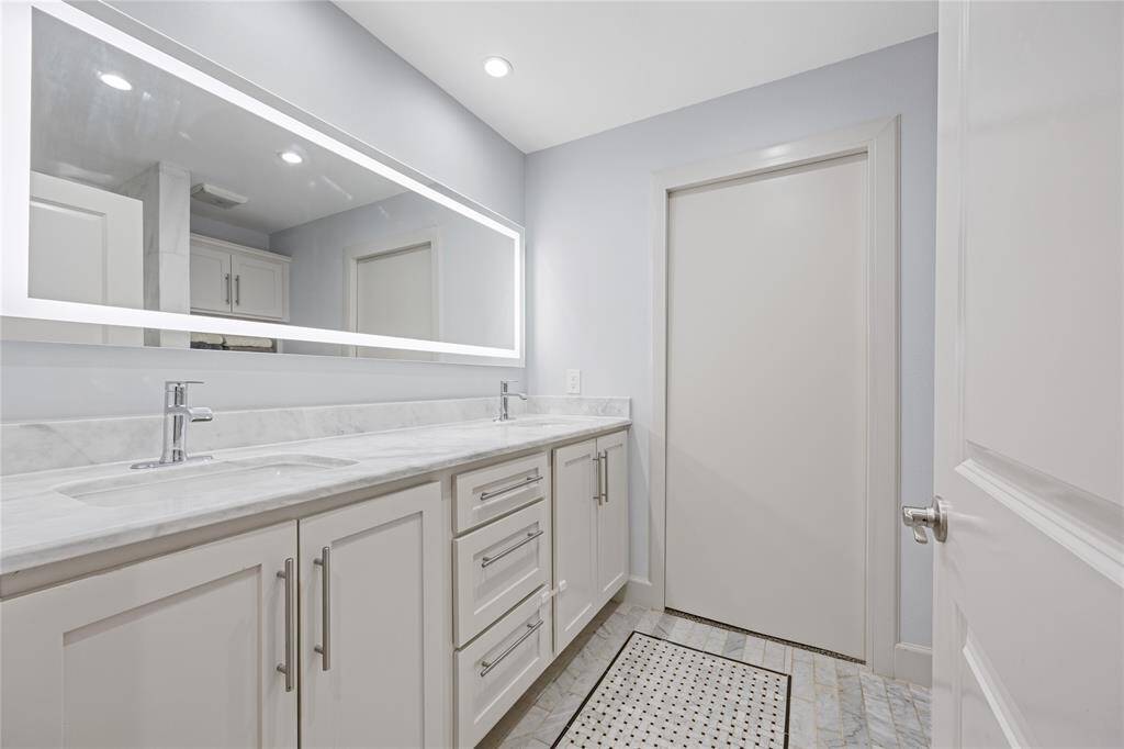Dual Vanity with Elegant Storage and Spa-Like DesignBright and spacious with high-end fixtures and integrated lighting, this vanity setup enhances the primary bathroom’s clean, modern appeal.