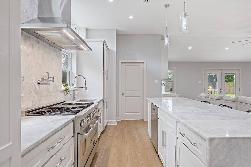 Close-Up of Cooking Zone with Dual Ovens and Commercial FaucetProfessional-grade appliances, pot filler, deep sink, and luxury faucet set into marble counters—perfect for those who love to cook and host.