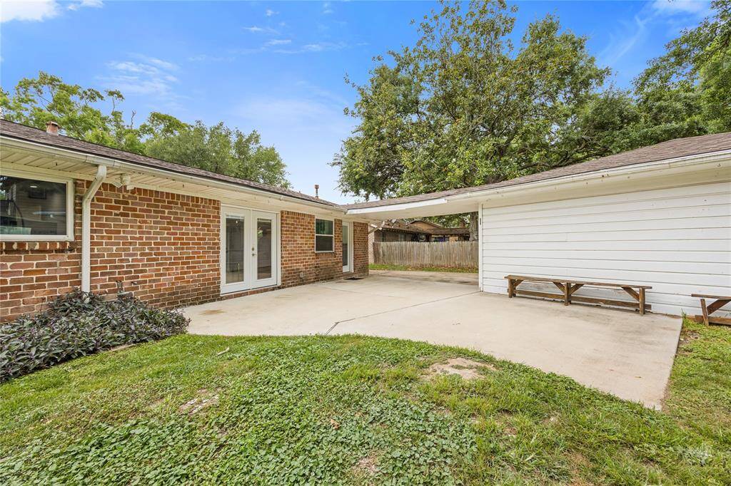 Rear Elevation + Dual French DoorsA rear view of the brick home featuring updated French doors that flood the living area with natural light and lead directly to the patio. Clean landscaping and fresh exterior lines make this yard move-in ready.