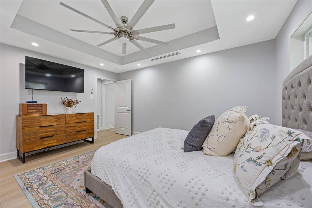 Primary Suite Angle Showing Fan, TV Mount, and Dresser WallThis angle shows the expansive feel of the primary bedroom with room for large furniture, flat-screen mount, and walk-in access to the ensuite bath.