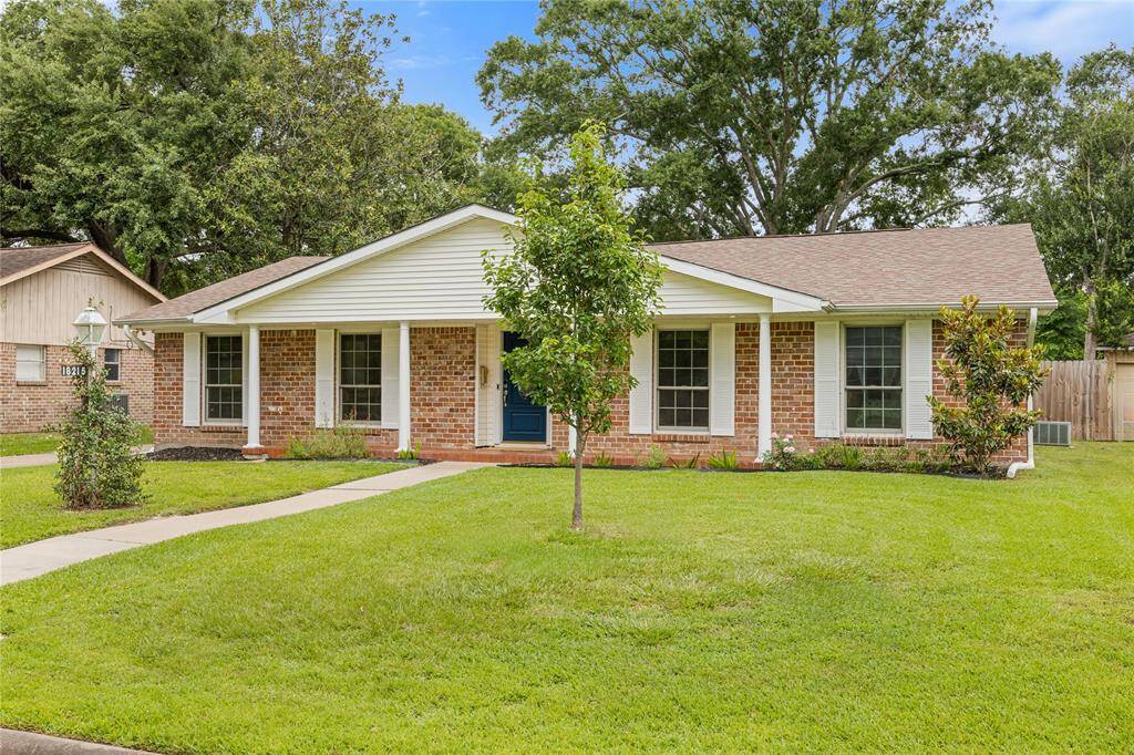 Angled Front Exterior with Side Yard ViewFeatures include new double-pane windows, fresh exterior trim, and manicured lawn. Highlights the home’s upgraded façade and mature neighborhood setting.