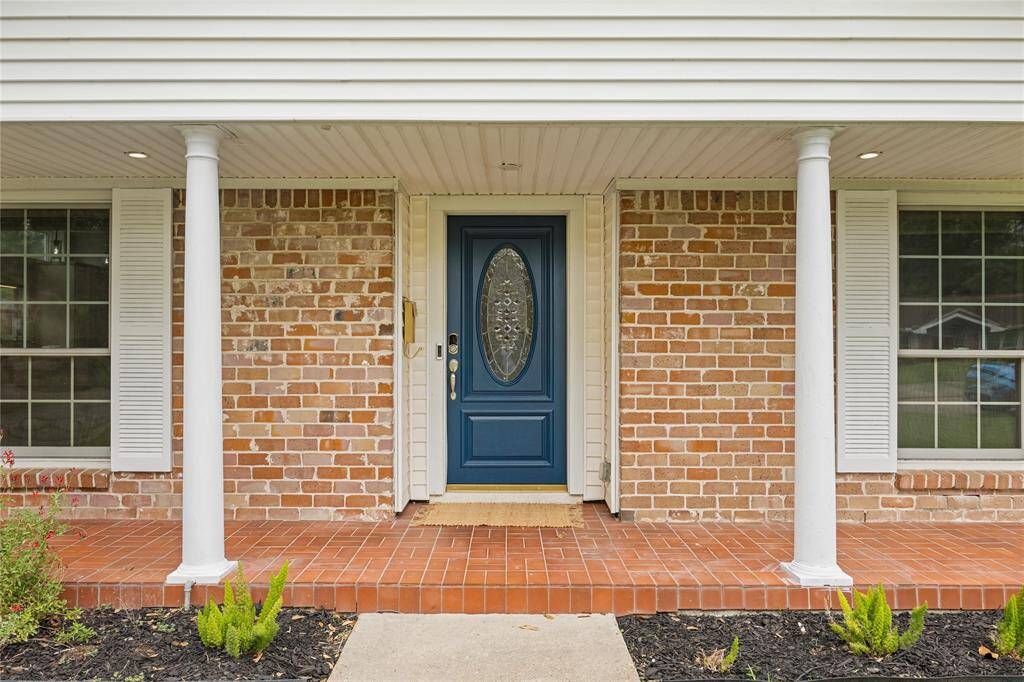 Front Porch and Entryway DetailBrick-front porch with tiled surface, white pillars, and upgraded oval-glass entry door. Ideal for buyers looking for homes with a welcoming front entry in Houston’s Nassau Bay area.