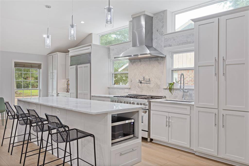 Bright and Functional Kitchen with Oversized Island & Custom Microwave ShelfFinal kitchen detail highlights built-in storage, high-end finishes, and additional prep space, making this kitchen a standout feature in Nassau Bay homes.