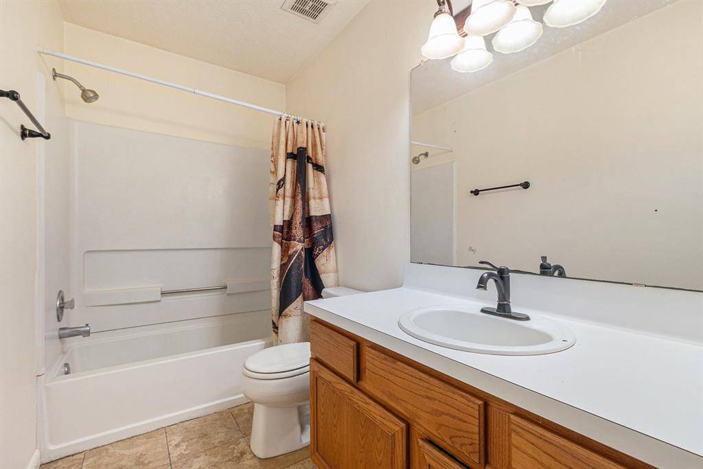 Secondary bathroom with a combination tub and shower.