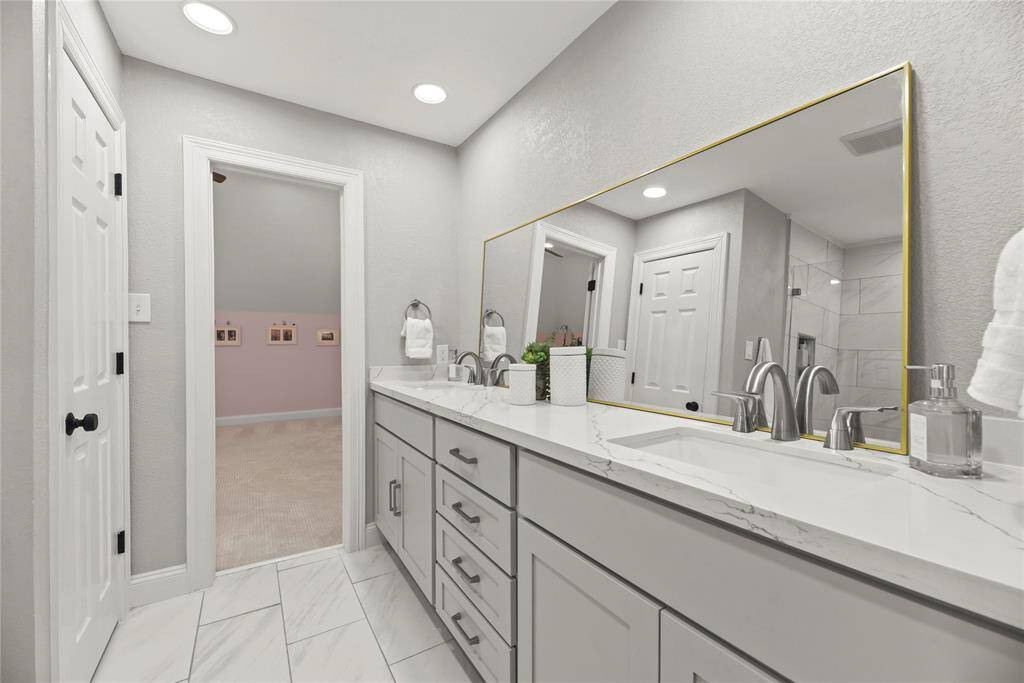 An updated Hollywood bath features updated cabinets, flooring, plumbing and lighting fixtures...