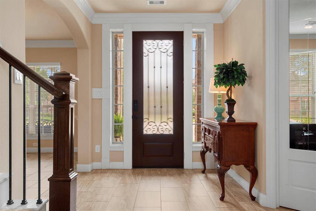 The stately front entrance makes a lasting first impression and sets the tone for the rest of the home.  Rich finishes, soaring ceilings and stylish lighting welcome guests.  This entrance is both beautiful and functional.