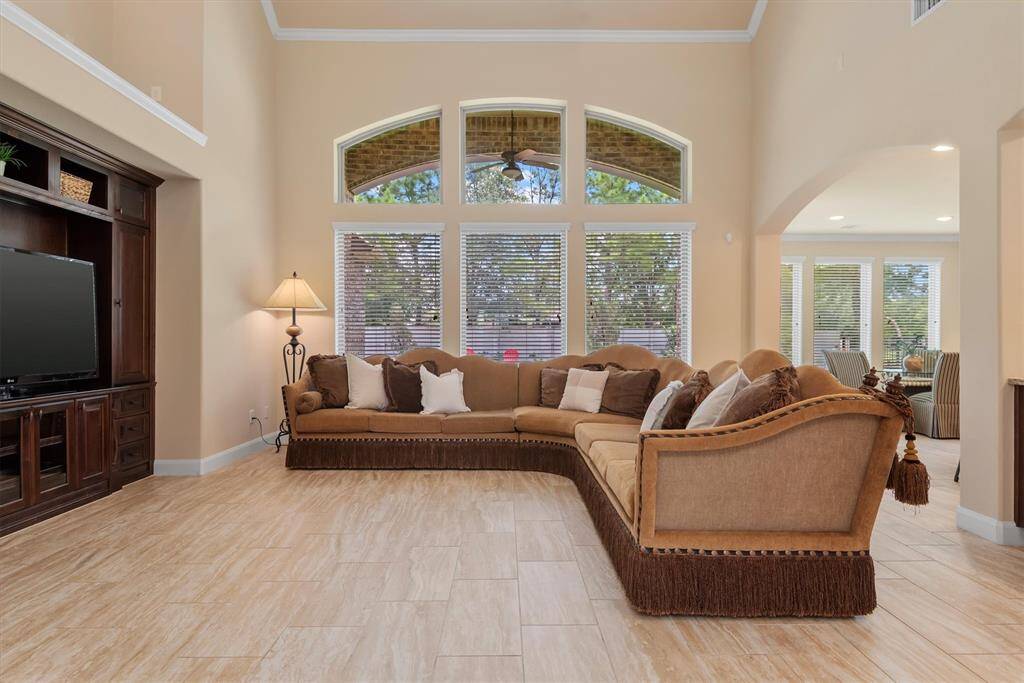 The living room is a showstopper with its soaring ceilings and dramatic, floor-to-ceiling windows that fill the space with natural light.