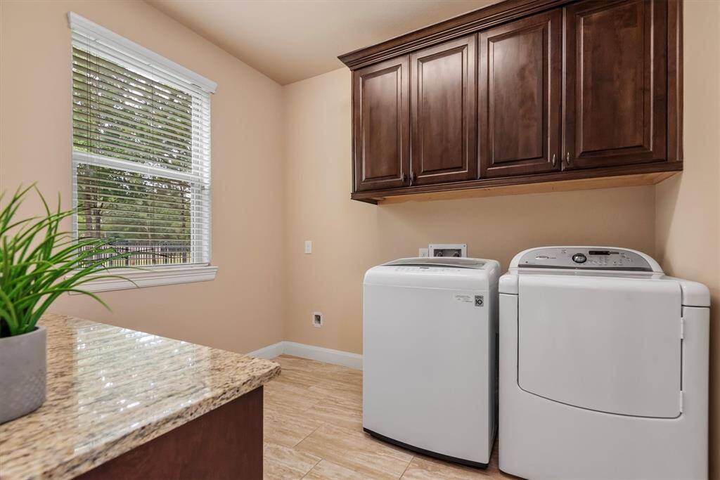 This oversized utility room is as functional as it is spacious, featuring built-in storage and plenty of room for an additional fridge or freezer.