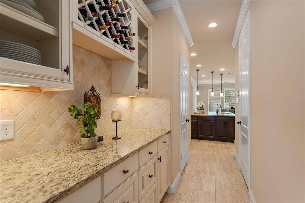 Conveniently located between the kitchen and formal dining area, the butler’s pantry adds both elegance and functionality. Perfect for serving, staging, or storing fine dinnerware, this thoughtfully placed space makes entertaining effortless. With stylish cabinetry and extra counter space, it creates a seamless flow from meal prep to memorable gatherings.
