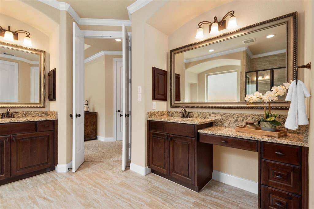 Step into a luxurious primary bathroom designed with comfort and sophistication in mind. Dual vanities provide ample space for morning routines, while a relaxing jetted tub and separate walk-in shower offer the perfect place to unwind. A massive walk-in closet ensures plenty of storage and refined architectural touches like arched entryways and custom niches add timeless elegance to this private retreat.