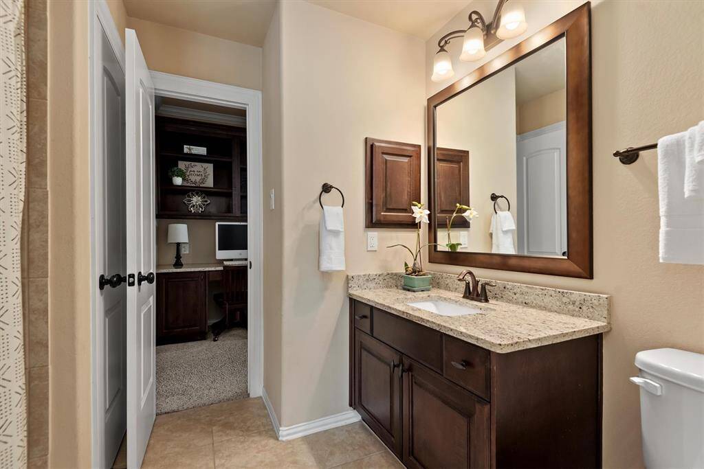 One of 2 upstairs secondary bathrooms offers access to the hallway for guests and direct access to the first secondary bedroom.