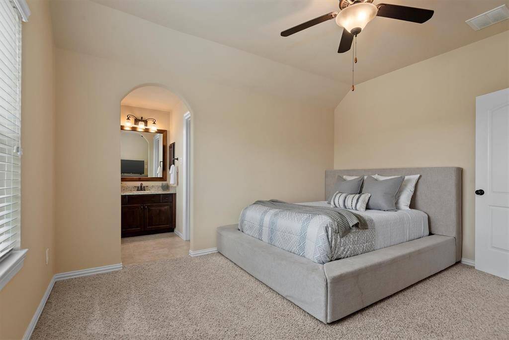 Another generously sized upstairs bedroom features direct access to a shared bathroom and a large walk-in closet.