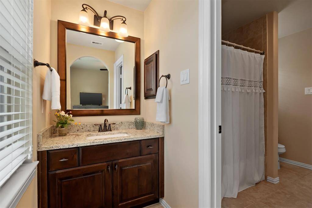 The shared connected bathroom has a vanity adjacent to each bedroom.  Only the tub and shower area are shared.