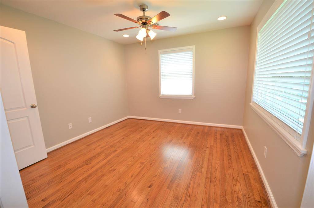 Secondary  bedroom with ceiling fan and beautiful hardwood floors.