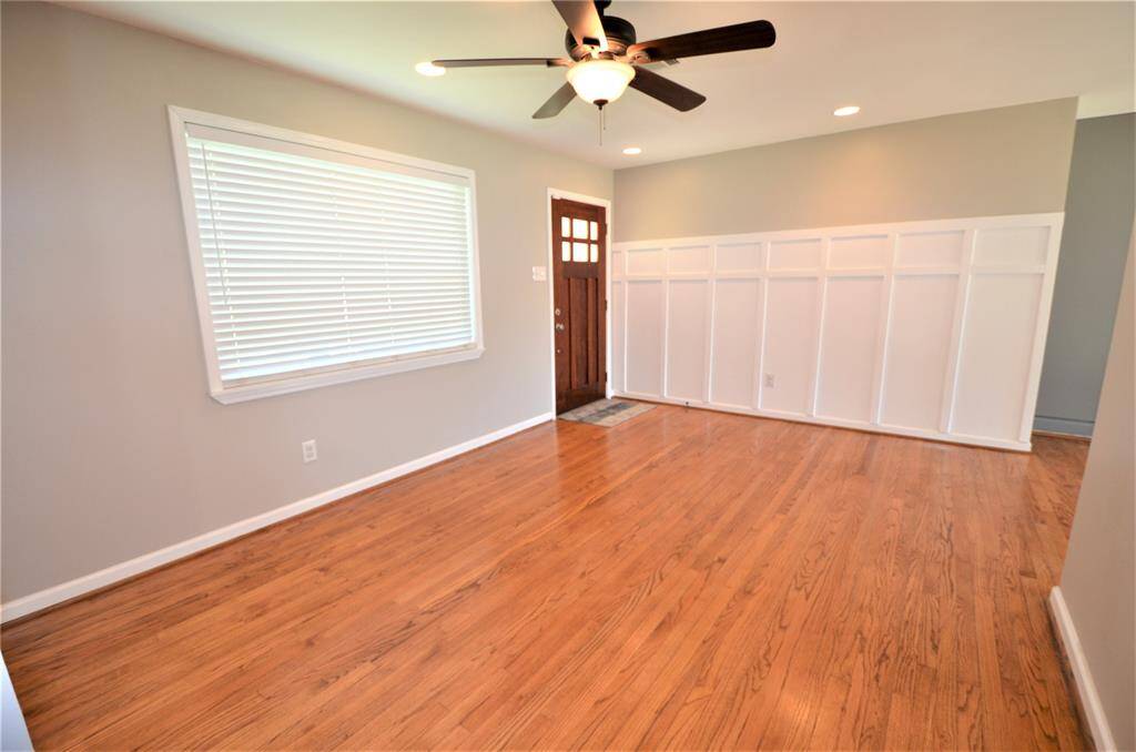 Living room with elegant block paneling, refinished hardwood floors, new windows and blinds.
