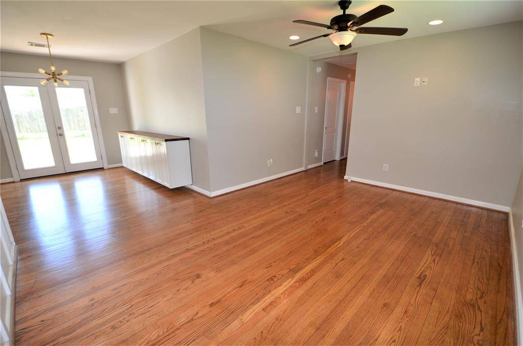 View of living and dining room with accent wall color in dining room and attached white cabinet.