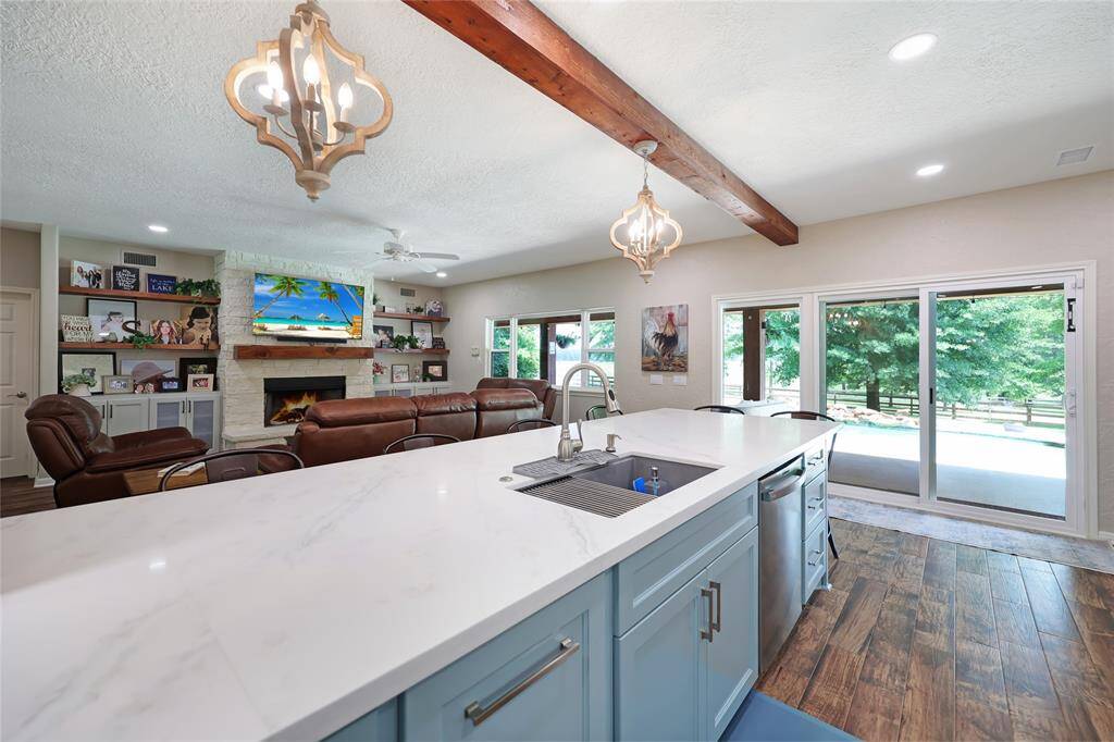 From this kitchen vantage point, enjoy open sightlines into the living room and panoramic views of the backyard and lake through expansive windows and glass sliders. The layout offers easy access to the patio and pool, seamlessly blending indoor comfort with outdoor living.