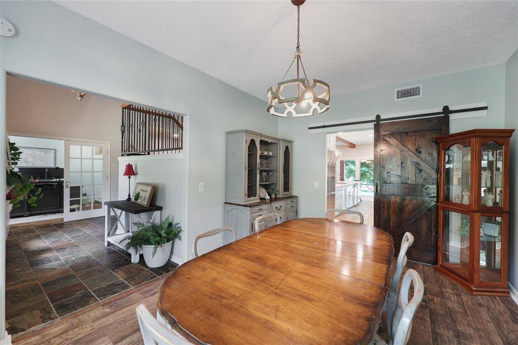 Just off the foyer is this inviting dining room which blends rustic charm and classic elegance. A sliding wood barn door adds character and separates the space from the kitchen.