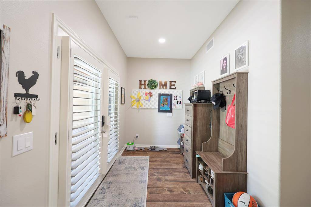 This back entry/mud room serves as a perfect drop zone and features elegant French doors with plantation shutters.