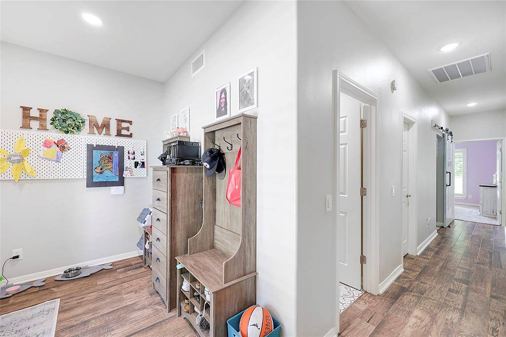 Just off the back entry/mud room is a hallway which leads to a massive pantry, utility room with sliding barn door, and a downstairs bedroom and full bath.
