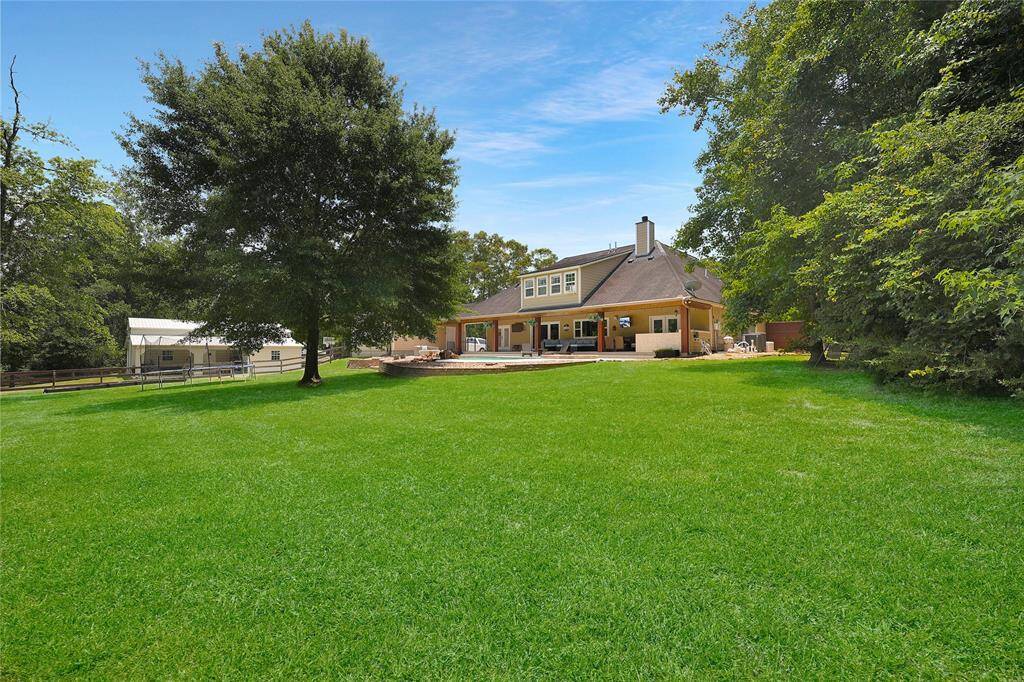 This wide-angle view captures the beautifully maintained backyard, featuring a lush green lawn with sprinkler system.