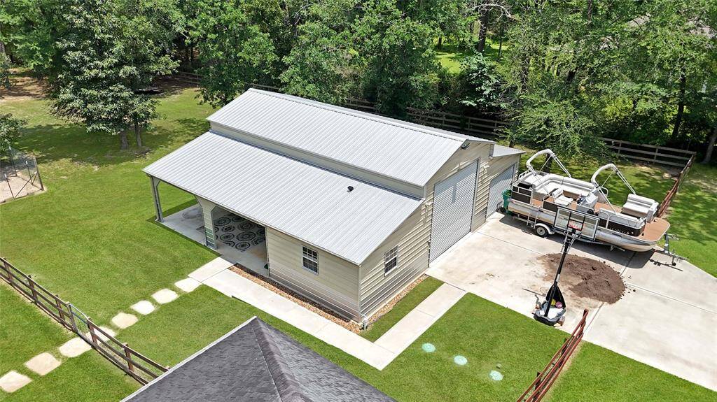 A stone path leads to the 40x42 metal building with lean-to. It has gutters and windows and a massive air conditioned storage space.