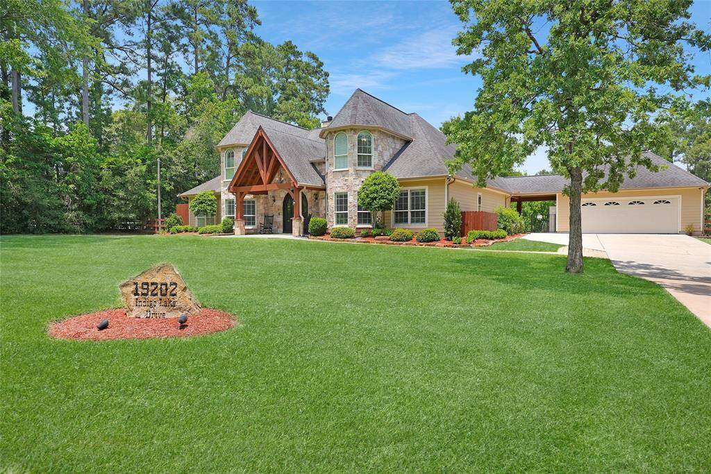 From the edge of the expansive front yard, this view captures the full grandeur of the home, including the oversized driveway and detached garage. The property marker carved into natural stone adds a personalized, upscale touch. The entire front, side and back yards are covered by a sprinkler system.