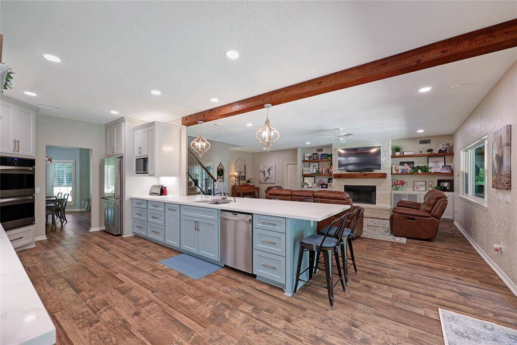 This view emphasizes the connection between kitchen, dining, and family room—an entertainer's dream. With dual ovens, generous storage, and custom lighting details, this kitchen has been thoughtfully designed for both everyday life and large gatherings.