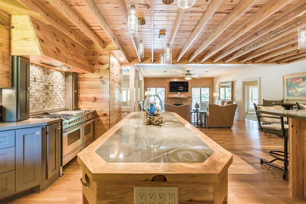 Beyond the kitchen, two sliding glass doors lead to a large, mostly covered deck with access to the pool.