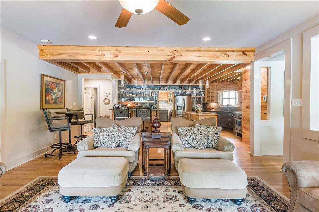 Great room with wood-burning fireplace, gas logs, and a custom mantel