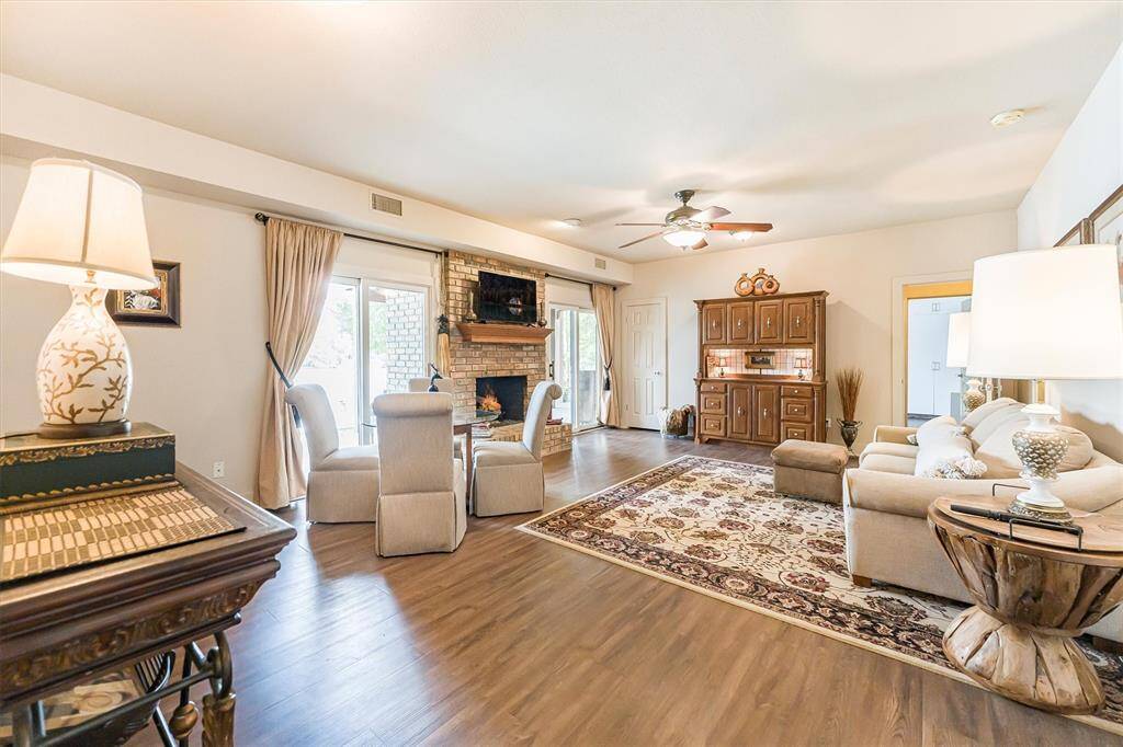 Large family room with two sliding glass doors to patio/pool and fireplace with gas logs