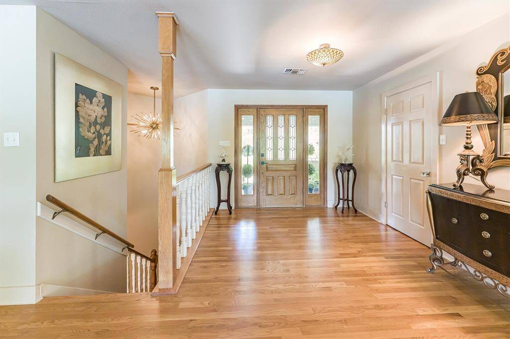 Foyer with a stairwell to the left leading down to the lower level. Electric chandelier with pulley for easy cleaning.