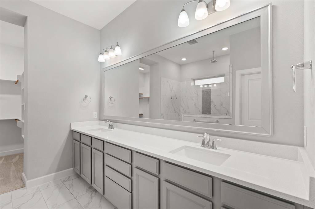 Fabulous white and grey tones for the Primary bathroom with double vanity and large framed mirror. Also connected to the bathroom is a large walk-in closet.