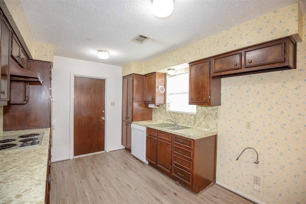 This charming kitchen features rich dark wood cabinetry that provides ample storage and timeless appeal.