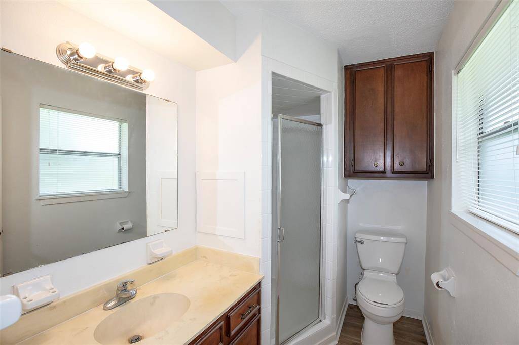 The primary bathroom features bright lighting and a linen cabinet.