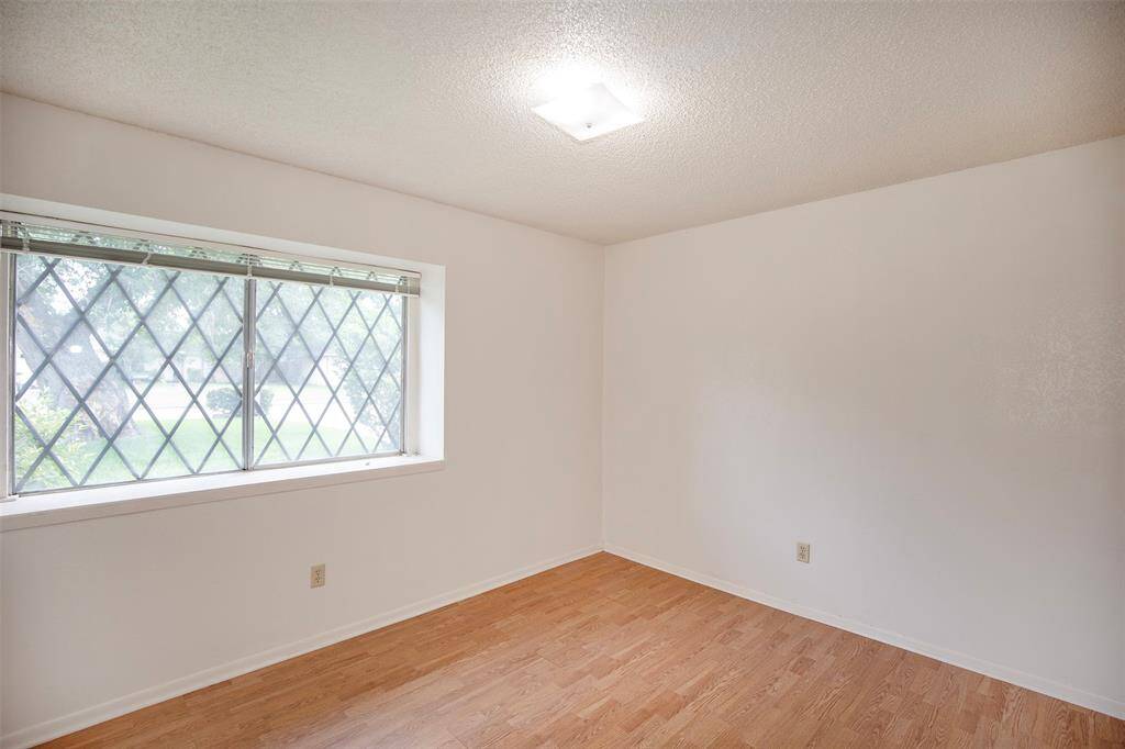 This secondary bedroom is filled with natural light, thanks to a large window that serves as a beautiful focal point.