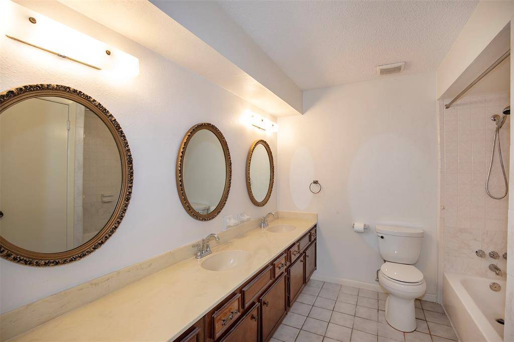 The guest bathroom features a long vanity with double sinks.