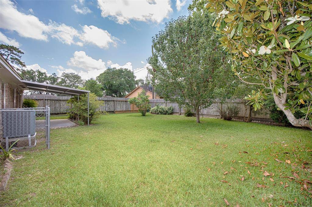 The backyard has mature trees that provide shade on a hot summer day.