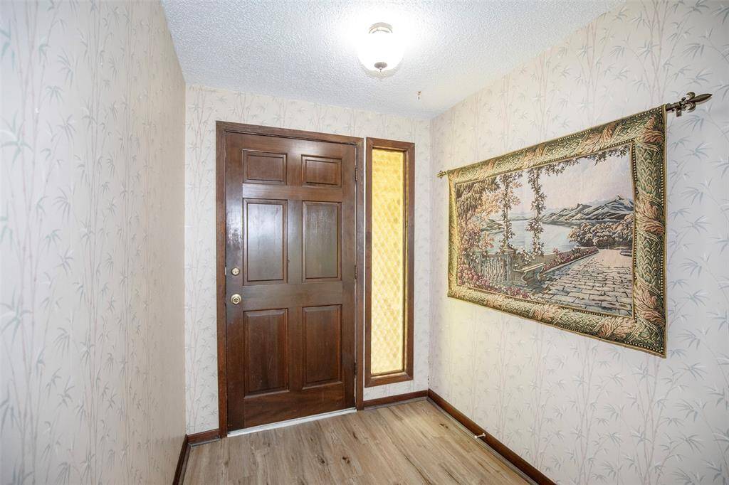 Step into this inviting entryway, where wallpaper adds a touch of personality and charm the moment you walk through the door.
