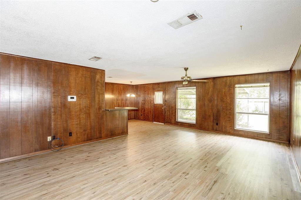 This spacious family room offers the perfect blend of comfort and openness, with large windows that overlook the backyard.