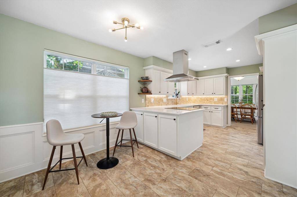 Bright, clean kitchen with peninsula, ample cabinets, and cozy breakfast nook