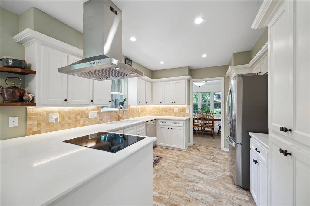 Clean kitchen featuring a peninsula and plenty of cabinets.