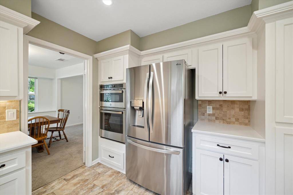 Modern kitchen with stainless steel appliances, plenty of cabinetries, and easy dining access.