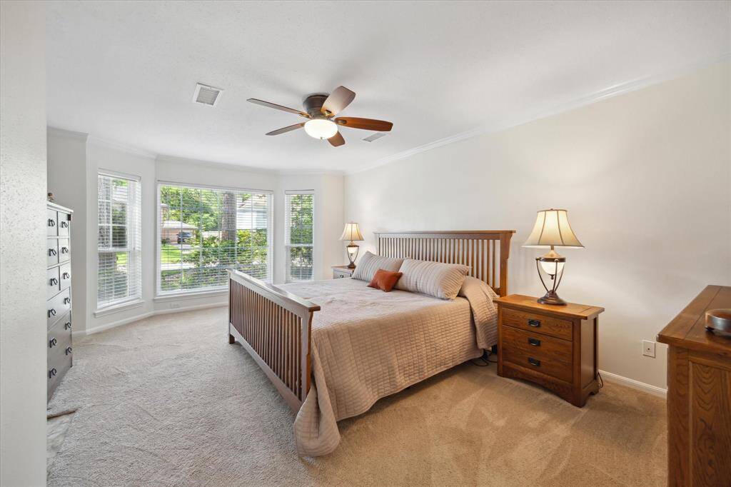 Airy primary bedroom featuring bright, open windows.