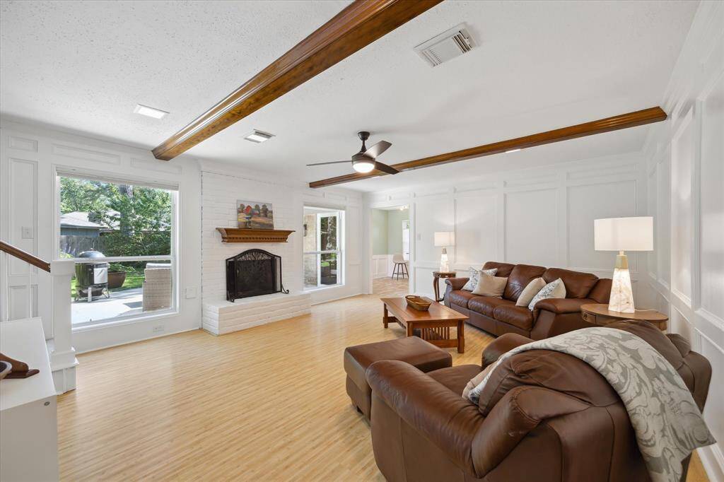 Spacious and bright living room with elegant wainscoting and fireplace focal point.
