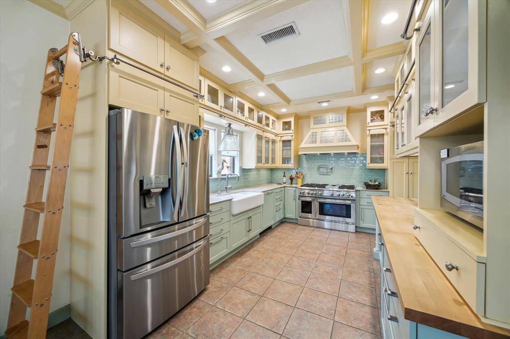 Custom kitchen with ladder to reach all of the cabinets. Soft close doors, built in trash can, 6 burner gas stove with griddle, undermount farmhouse sink with instant hot water.