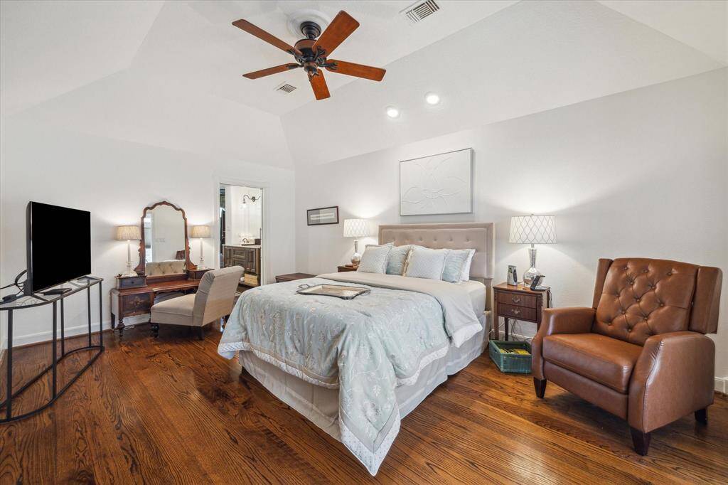 The primary bedroom has stately wood floors and an en suite bathroom.