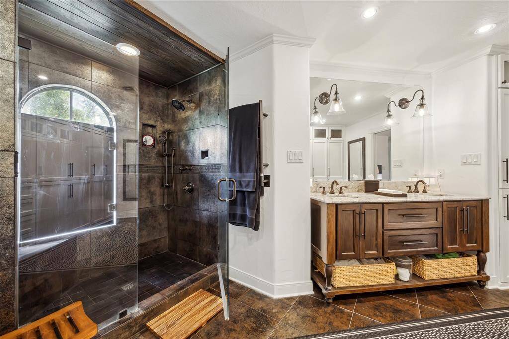 Primary shower with heated towel warmer and custom vanity.