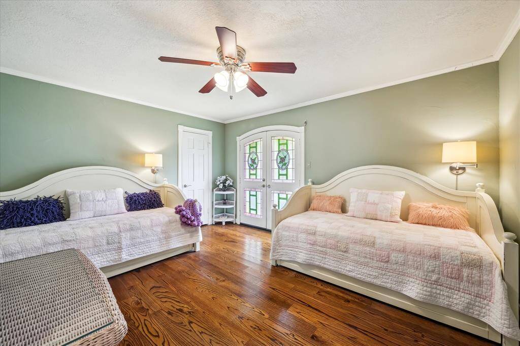 Secondary bedroom with wood floors and a small balcony.